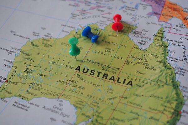 Close-up of a map of Australia featuring colorful pushpins marking locations.